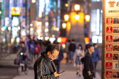 People on illuminated street at night