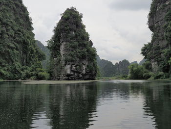 Scenic view of lake by trees against sky