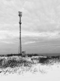 Windmill on field against sky during winter