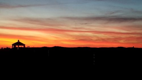 Silhouette buildings against sky during sunset