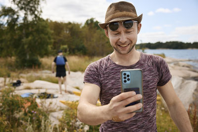 Smiling man at coast taking selfie