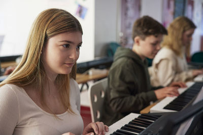 Teenagers attending keyboard lesson