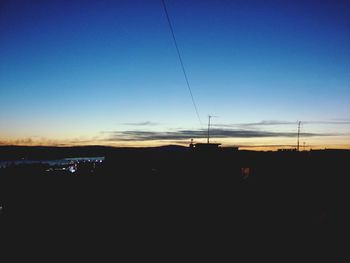 Silhouette of electricity pylon at sunset