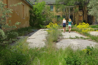 Full length of girls walking against old abandoned building