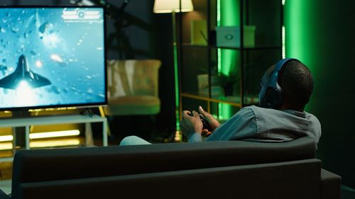 Rear view of woman sitting on sofa at home