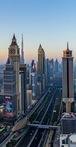 Aerial view of road amidst buildings against clear sky in city during sunset