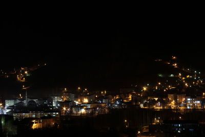 Illuminated cityscape against sky at night