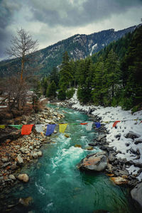 Scenic view of river and mountains against sky