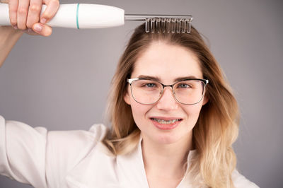 Portrait of smiling young woman holding hairbrush