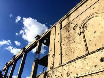 Low angle view of damaged building against sky