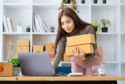 Portrait of young woman using laptop at home