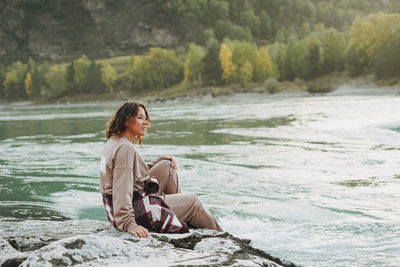 Young woman traveller in casual with backpack on the mountain river on sunset