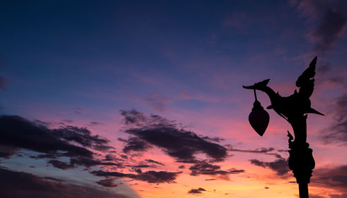 Low angle view of silhouette plant against dramatic sky during sunset