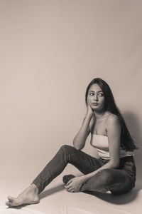 Portrait of woman sitting against wall