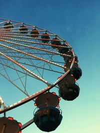 Low angle view of ferris wheel against clear blue sky