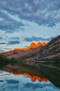 Sunset over mountain by colorado river in moab, utah.