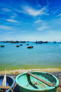 Sailboats moored on sea against sky