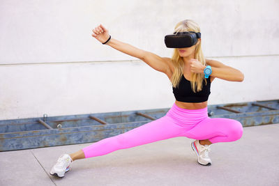 Full length of young woman exercising in gym