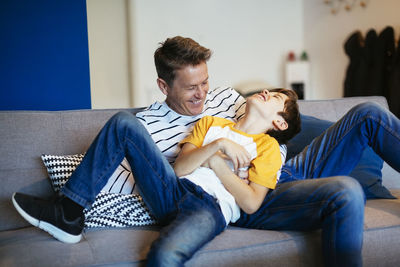 Friends sitting on sofa at home