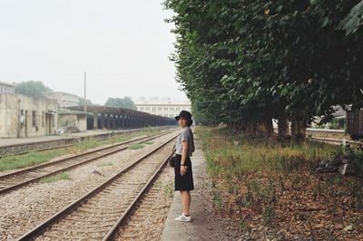 Rear view of woman walking on railroad track