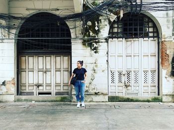 Full length of woman standing against building in city