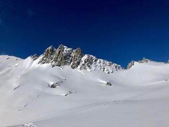 Scenic view of snowcapped mountain against blue sky