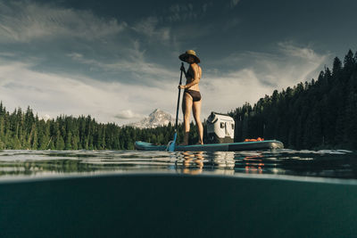 A young woman enjoys a standup paddle board on lost lake in oregon.