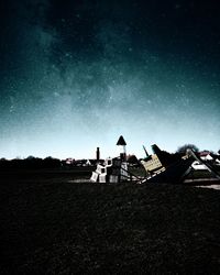 Houses on field against sky at night