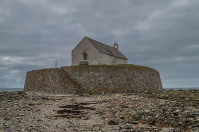 Low angle view of old building on field against sky