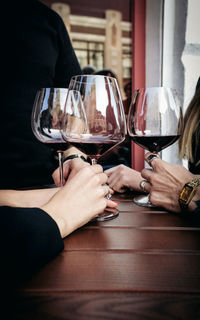 Cropped image of people having drink in restaurant