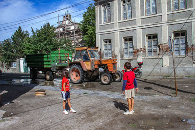 People working on motorcycle against sky in city