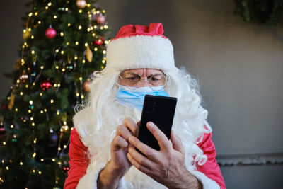 Santa claus using smart phone at home