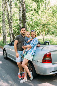 Mom, dad and little son in a convertible car. summer family road trip to nature