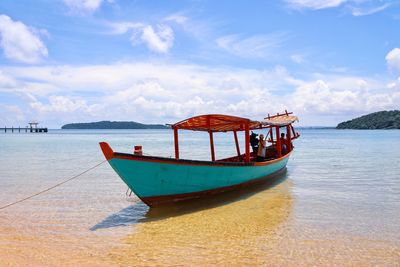 Boat moored on sea against sky