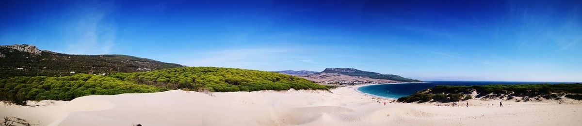 Scenic view of beach against blue sky