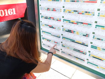 Rear view of woman pointing at colorful chart