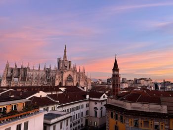 Buildings in city against sky during sunset