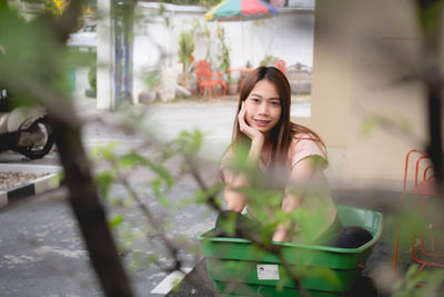 Portrait of smiling young woman sitting outdoors