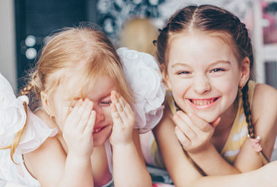 Portrait of happy girls lying at home