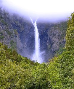 Scenic view of waterfall against sky