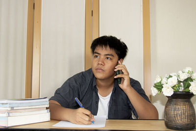 Portrait of young man sitting on table