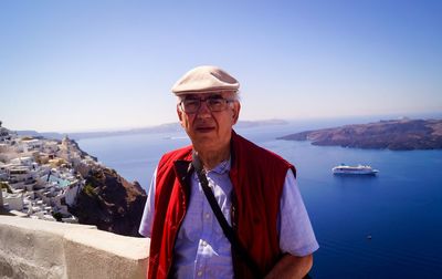 Portrait of senior man with sea in background against clear sky