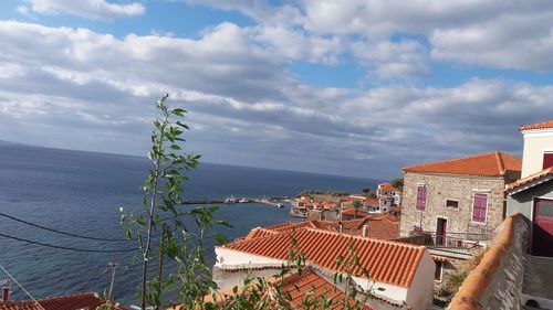 High angle view of houses by sea against sky