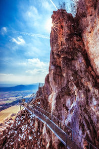 Rock formations on mountain against cloudy sky