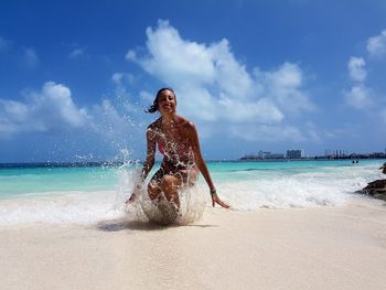 Full length of woman on beach against sky