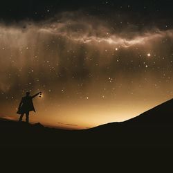 Silhouette landscape against sky at night