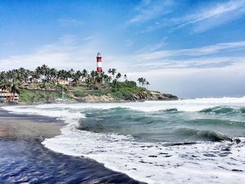 Lighthouse by sea against sky