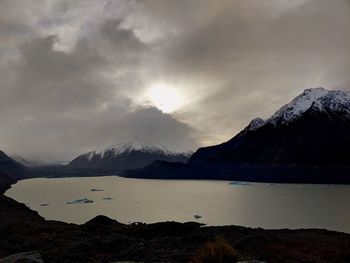 Scenic view of lake and snowcapped mountains against sky