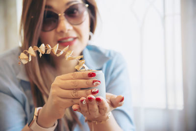 Close-up portrait of woman wearing sunglasses holding pot