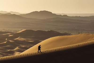 Man of sand dune against sky